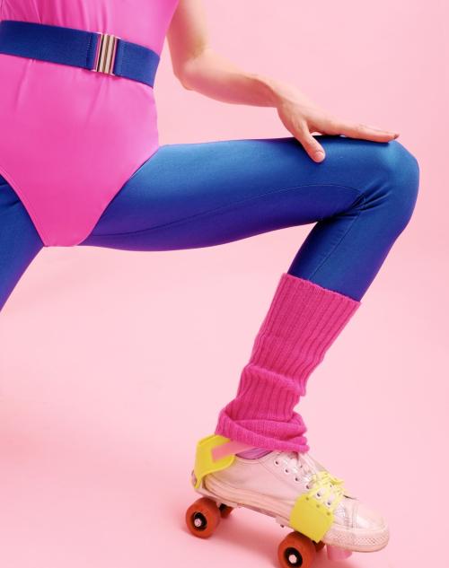 Крупний план вінтажних роликових ковзанів з помаранчевими колесами та рожевих гетрів