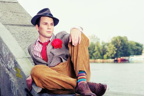 Чоловічий ретро-образ 50-х: піджак з червоною квіткою, смугаста сорочка та капелюх.