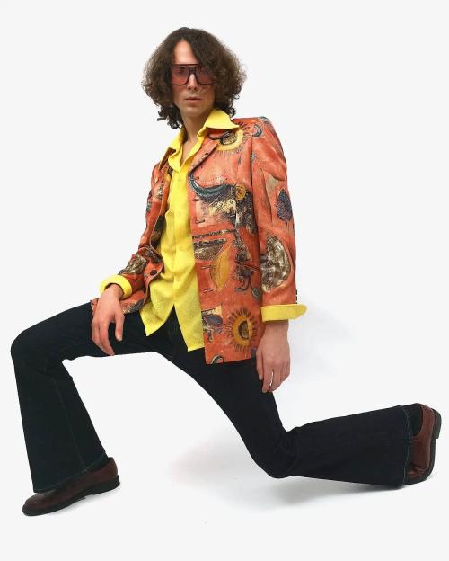 Чоловічий образ 70-х: піджак з художнім принтом, жовта сорочка та джинси-кльош